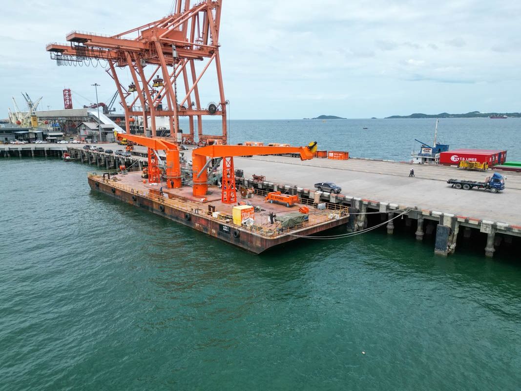 Barge with two cranes alongside the quay